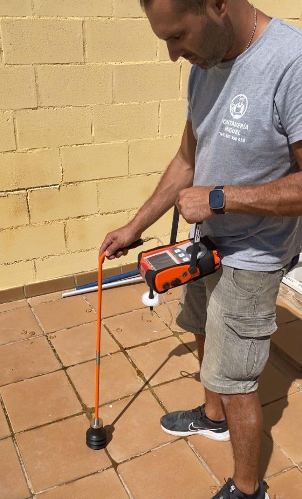 Fontanero inspeccionando el suelo con herramientas avanzadas